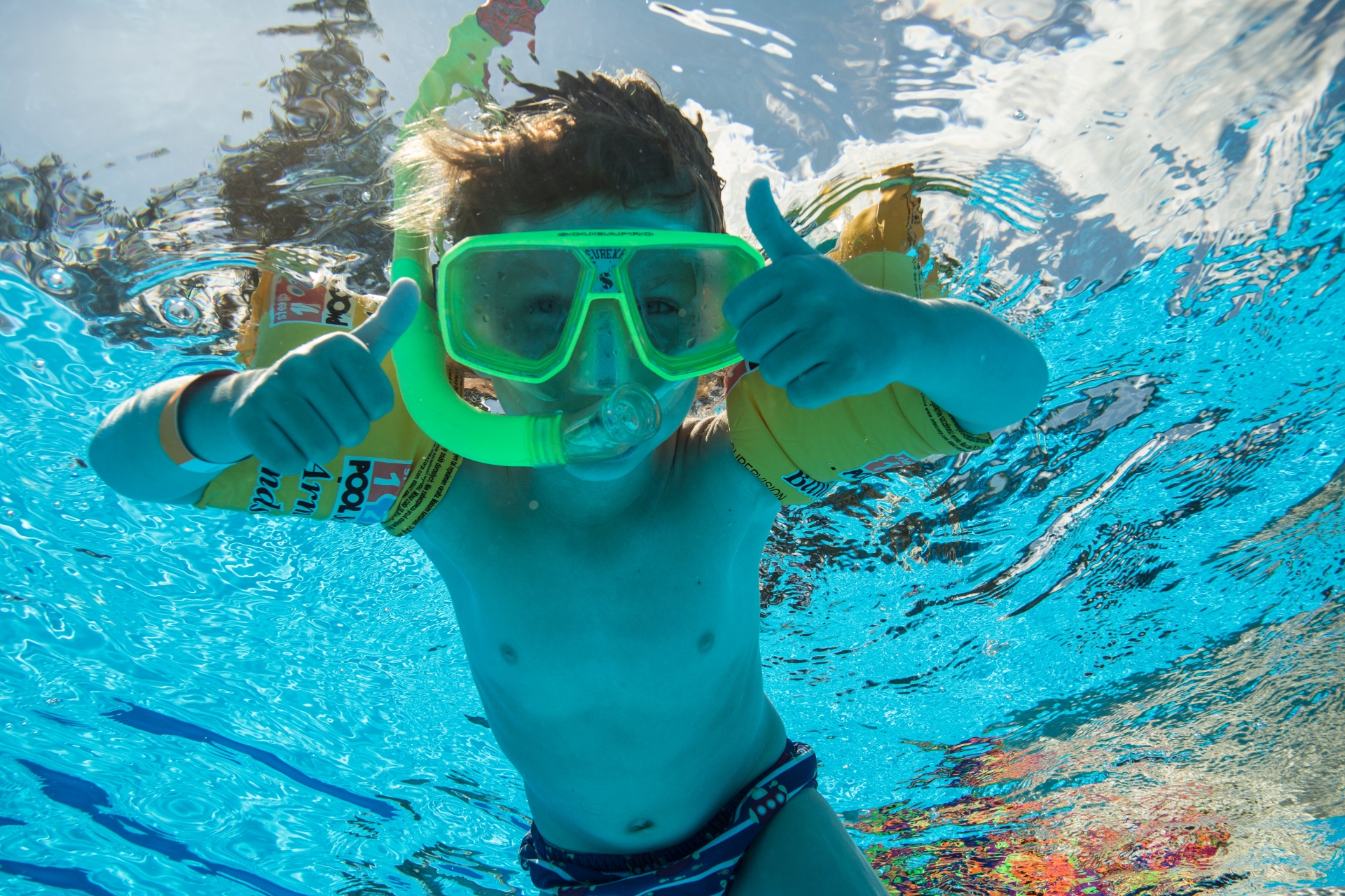プールで遊ぶ幼児と親