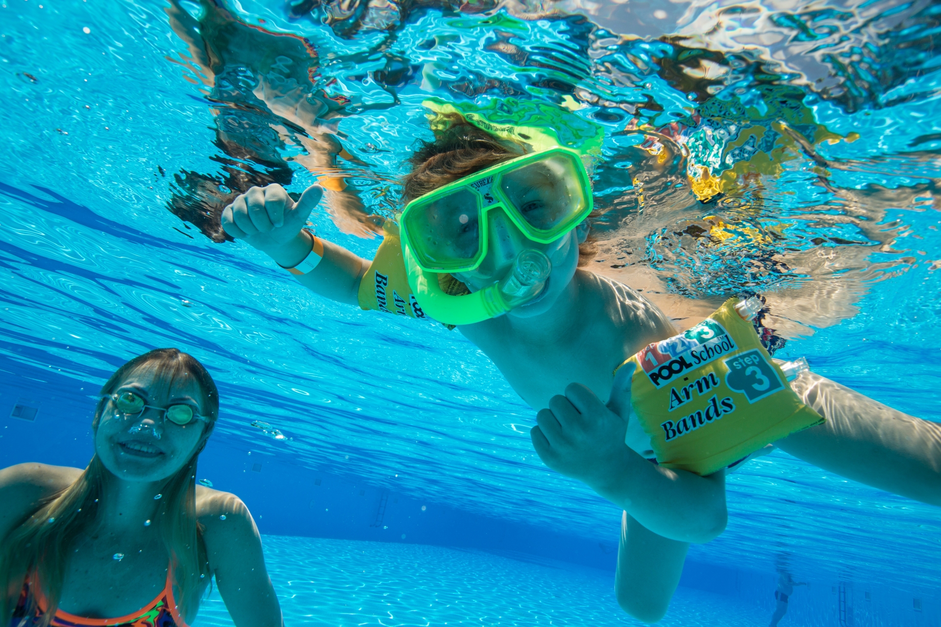 空いているサマーランドのプールで遊ぶ子ども