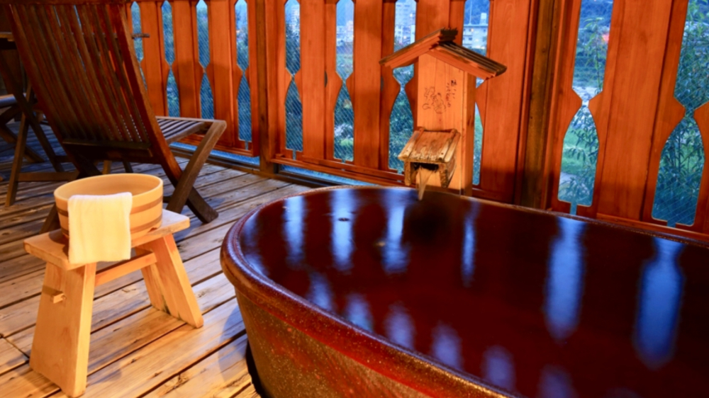 望川館のキッズスペースで遊ぶ子どもたちと庭園を散策する家族