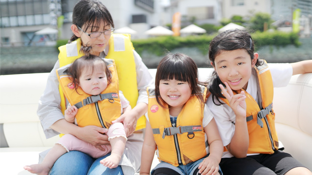 2-4歳の幼児が親と一緒に安全に釣り体験をしている様子、ライフジャケット着用で海辺で遊ぶ姿