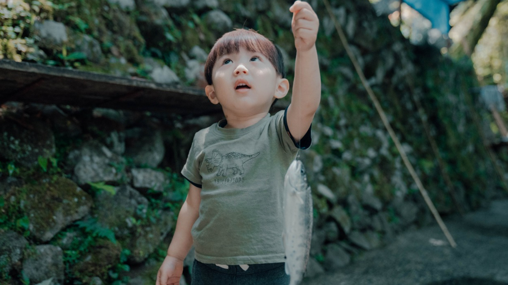釣り旅行から帰った家族が笑顔で体験談を話している様子